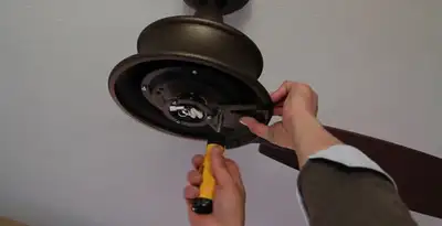 Electrician installing ceiling fan mounting bracket and fixture in Los Angeles, CA