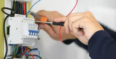 Electrician installing and adjusting circuit breakers in an electrical panel in Los Angeles, CA