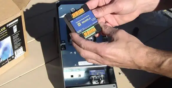 Electrician installing whole home surge protection unit inside main electrical panel in Los Angeles, CA