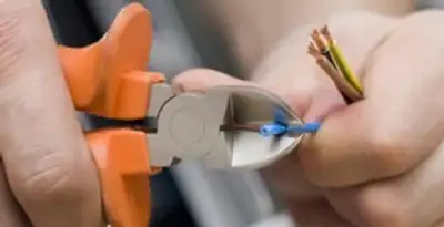 licensed electrician performing precise wire cutting and preparation during electrical service in Los Angeles, CA