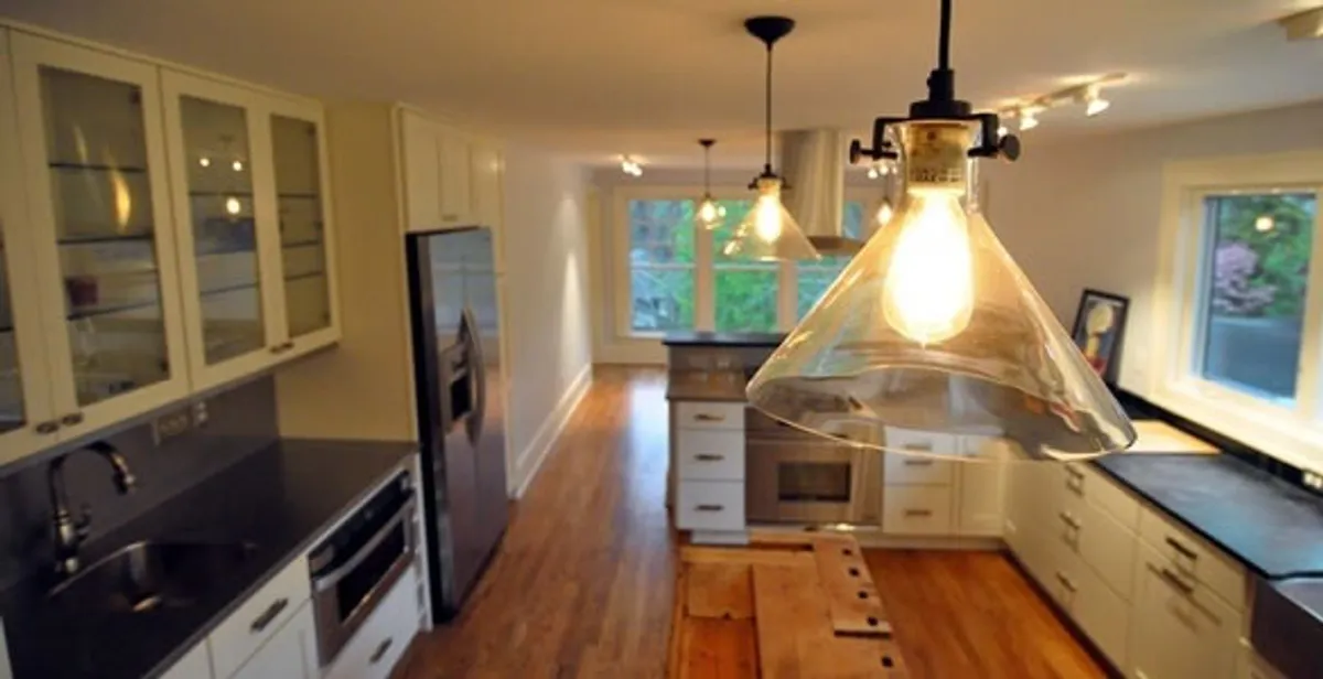 Residential electrician installing modern indoor light fixture in a home in Los Angeles, CA