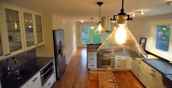 Residential electrician installing modern indoor light fixture in a home in Los Angeles, CA